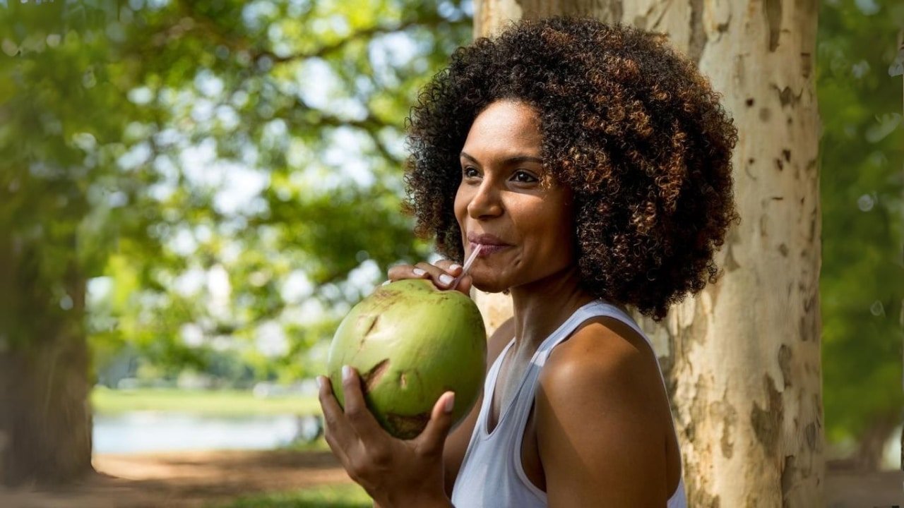 Brazilian woman drinking a coconut in Rio de Janeiro, Brazil.