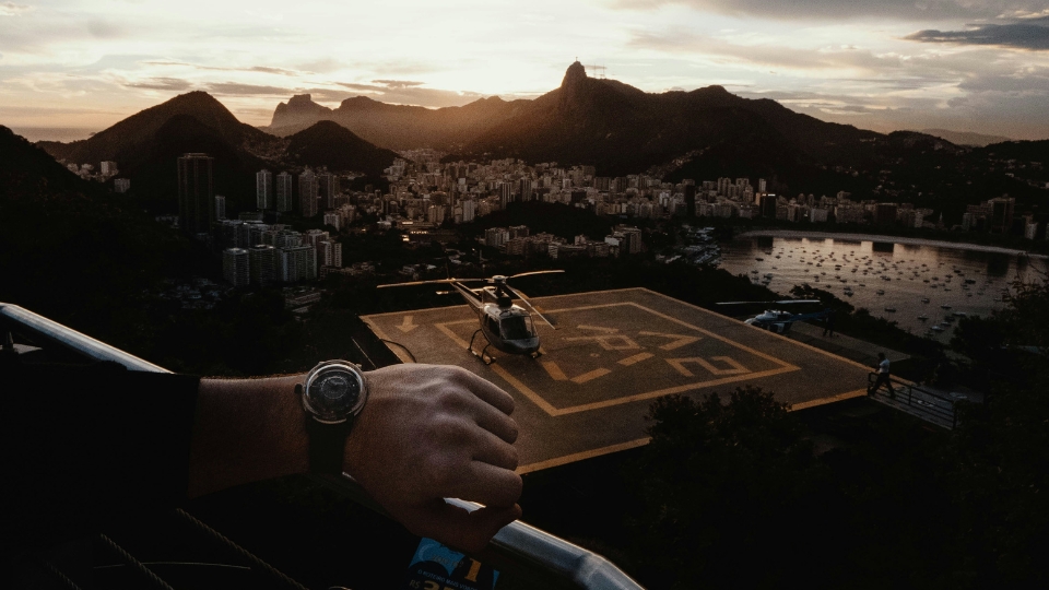 What to do in Rio (1) Helicopter on the Sugarloaf helipad overlooking Rio de Janeiro’s coastline and skyline, highlighting the exclusive travel experiences Brazil Exclusive Travels presents at ILTM Cannes.