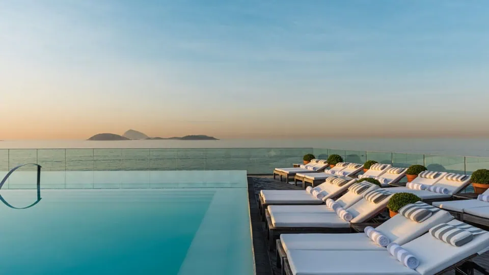 Rooftop pool at Fasano Ipanema overlooking the ocean and mountains, showcasing exclusive Rio de Janeiro experiences arranged by a high-end travel agency for guests traveling from Canada.