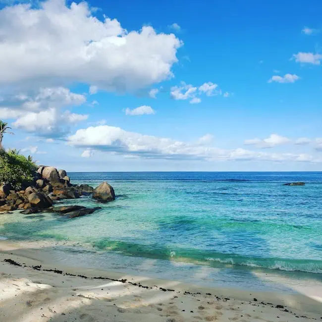 pexels-photo-14371170-14371170 Scenic tropical beach with azure waters, clear sky, and fluffy clouds.