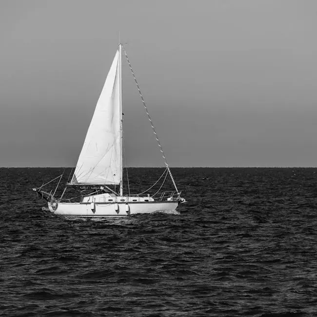 pexels-photo-35241781-35241781 A serene sailboat captured in black and white sailing across a calm sea under a clear sky.