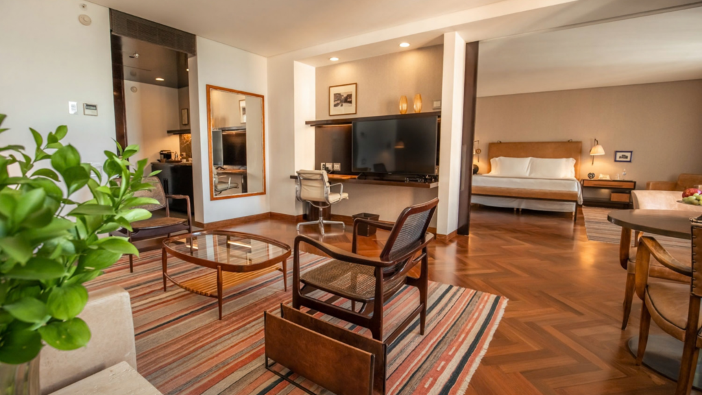 Fasano São Paulo - Hotel Booking in Sao Paulo (6) Spacious hotel suite with seating area, flat-screen TV, and bedroom in Fasano São Paulo.